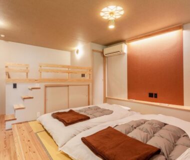 Two futon beds on wooden floor with loft ladder and warm lighting at Misenkan in Nara, Kansai, Japan