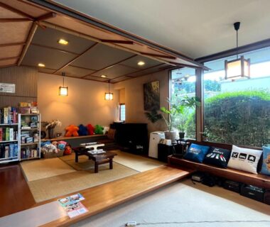 Tatami seating area with low table, cushions and garden view at Mitake ryokan, Kanagawa, Kantō