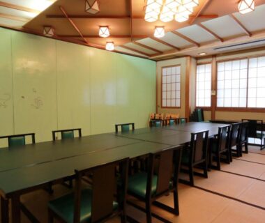 Long tatami dining room with low table and chairs, shoji screens at Mitake ryokan in Kanagawa, Japan