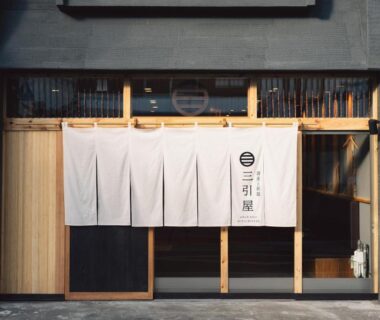 Traditional white noren over wooden sliding entrance with vertical slats at Mitsubikiya in Nagano, Chūbu