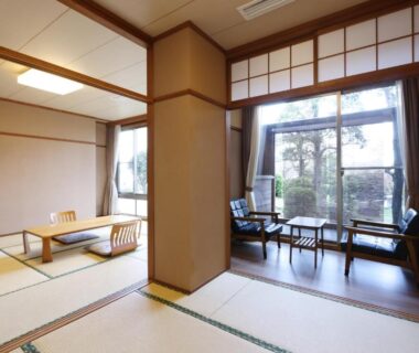 Spacious tatami room with low table, shoji screens and window seating at Miyahama Grand Hotel, Hiroshima Prefecture