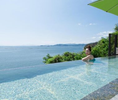Guest relaxing in seaside infinity pool at Miyahama Grand Hotel on Hiroshima coast