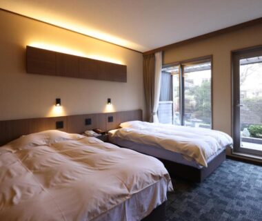 Twin beds with floor-to-ceiling windows overlooking a small garden at Miyahama Grand Hotel Hiroshima