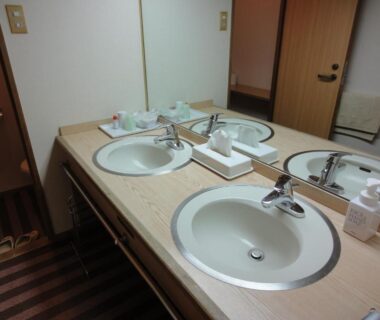 Twin sink vanity with mirror, toiletries and towels at Miyajima Hotel Makoto in Hiroshima
