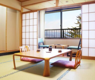Tatami room with low table, cushions, shoji screens and balcony at Miyajima Morinoyado, Hiroshima