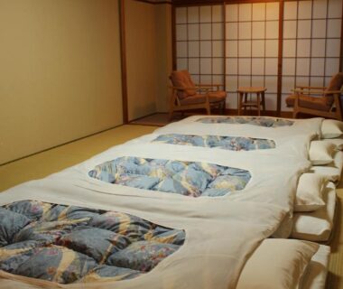 Traditional tatami room with futon bedding, shoji screens and low chairs at Miyajima Seaside Hotel in Hiroshima