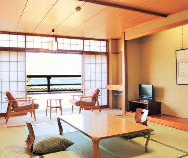 Traditional tatami room with low table, shoji screens and sea view at Miyajima Seaside Hotel in Hiroshima