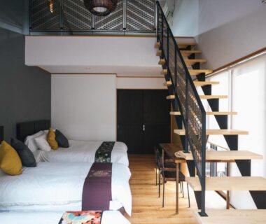 Loft-style twin bedroom with wooden staircase and modern bedding at Miyajima Shiro Hiroshima