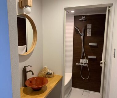 Small bathroom with wooden sink counter and shower at Miyajima Shiro in Chūgoku, Hiroshima, Japan