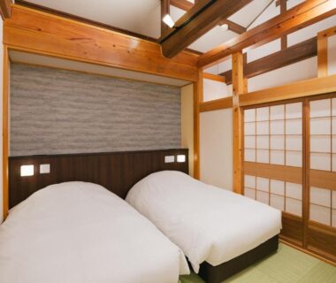 Tatami room with twin beds, shoji screens and wooden beams at Miyama Ouan in Gifu Chūbu Japan