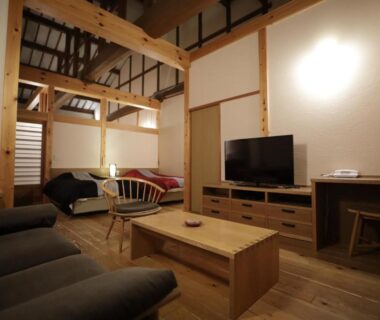 Interior lounge with exposed beams, sofas and TV at Miyama Ouan, Chūbu Gifu