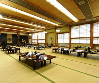 Large tatami dining room with low tables set for meals at Miyamaso in Gifu, Chūbu, Japan