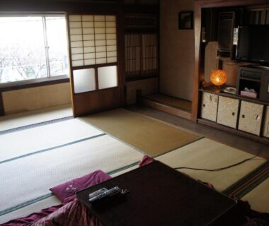 Traditional tatami room with low table, zabuton cushions and shoji screens at Miyoshiya Ryokan in Wakayama