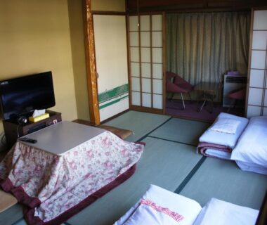 Traditional tatami room with futon bedding, low kotatsu table and shoji screens at Miyoshiya Ryokan in Wakayama