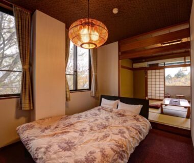 Western bed and adjoining tatami seating area with shoji screens at Mizu no Kaori in Kanagawa