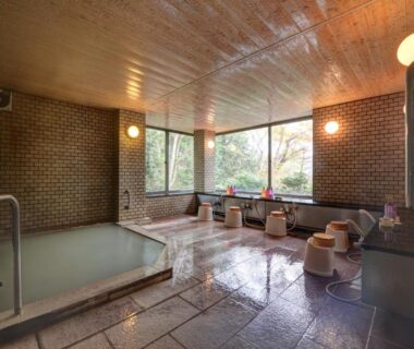 Tiled indoor onsen with washing area and garden-facing windows at Mizu no Kaori, Kanagawa