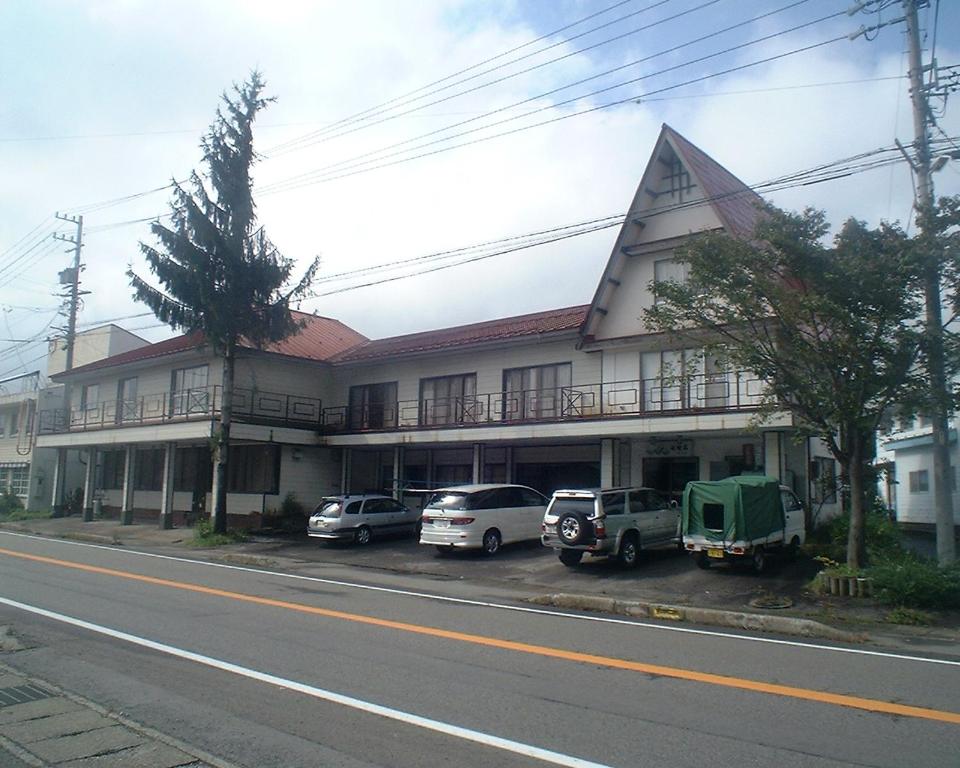 Roadside two-story ryokan Mizubaso Gifu Japan Two-story ryokan facade with balcony, parked cars and street in Gifu, Chūbu, Japan