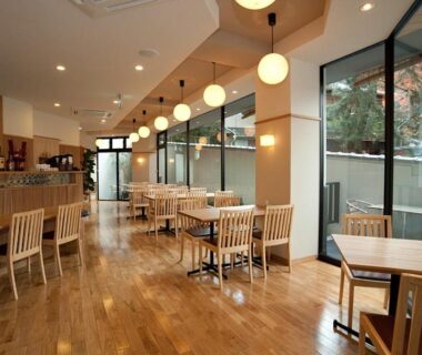 Spacious wooden dining room with pendant lights and floor-to-ceiling windows at Mizuhasou, Hiroshima