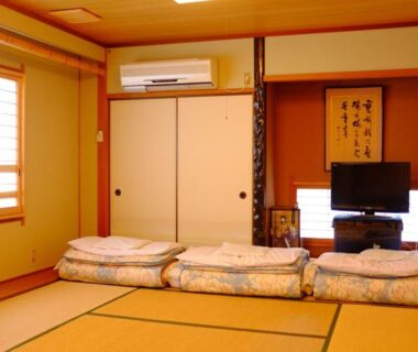 Traditional tatami room with folded futons, shoji window and calligraphy scroll at Mizuhokan in Mie, Kansai