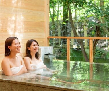 Two guests soaking in indoor bath with garden view at Mizumari ryokan, Shizuoka, Chūbu