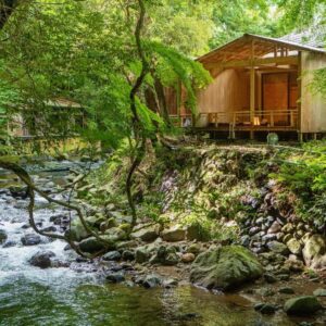 Riverside wooden cabin with deck beside mossy stream at Mizumari in Shizuoka, Chūbu Japan