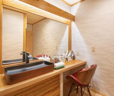 Wooden vanity with black basin, mirror, toiletries and chair in Mizumari wash area, Shizuoka, Chūbu, Japan