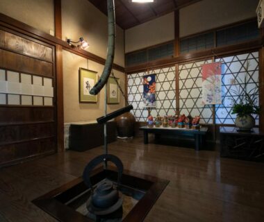 Sunken irori hearth with hanging kettle, wooden interior, shoji screens and bench seating at Mizuno Ryokan, Saga