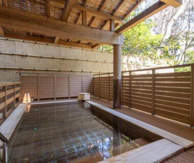 Covered wooden soaking bath with bamboo blinds and wooden fence at Mizunoto ryokan in Kanagawa