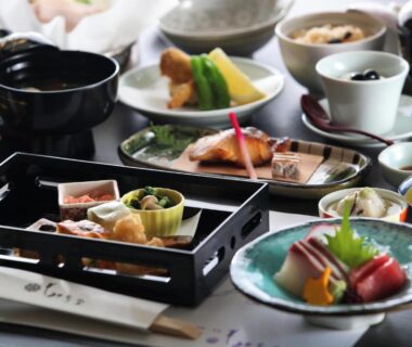 Assorted small dishes and sliced fish on lacquer trays at Momijiya Annex, Kyoto ryokan