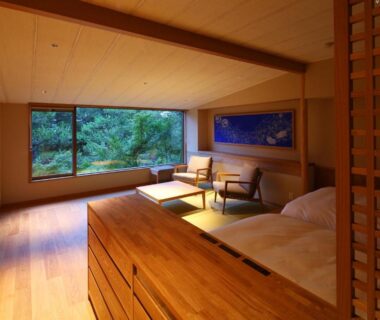 Minimal tatami room with low table, seating, shoji screen and large window overlooking greenery at Monjusou, Kyoto