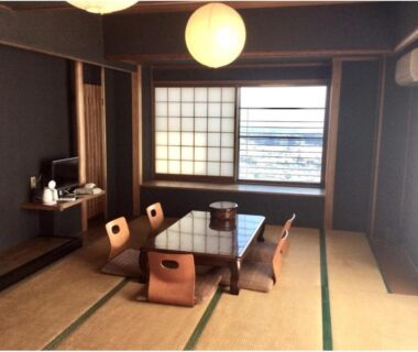Tatami room with low table, floor chairs, shoji screens and window at Monzen Okagero in Nara