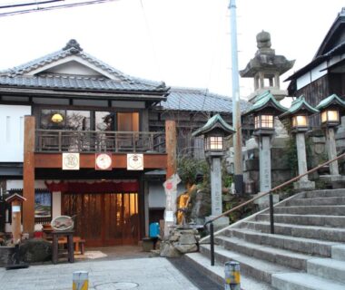 Traditional ryokan entrance with stone lanterns and steps at Monzen Okagero in Nara