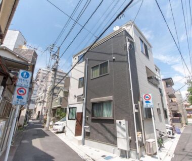 Narrow urban street with three story building and overhead wires at Mori House In 西日暮里I in Tokyo, Kantō
