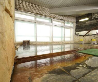 Indoor onsen bathing area with wooden edge and stone floor at Mori no RyoTei, Fukushima