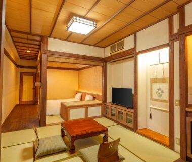 Tatami room with low table, floor cushions, alcove, and raised sleeping area at Mori no yu Kira No Sato, Shizuoka