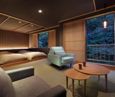Spacious tatami room with low beds, lounge seating, shoji screens and forest view at Moritaya in Fukushima