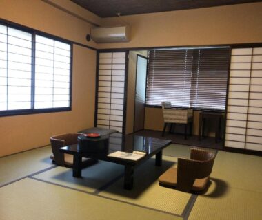 Traditional tatami room with low table, floor chairs, shoji screens and window at Mount View Hakone in Kanagawa