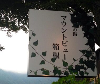 White vertical sign with Japanese characters and ivy, misty mountain backdrop at Mount View Hakone Kanagawa