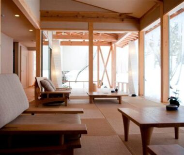 Tatami seating with low wooden tables and large windows overlooking snow at Mozumo ryokan, Gifu, Chūbu