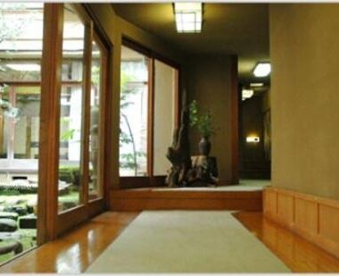 Tatami mat corridor with wooden flooring and glass doors overlooking a serene courtyard garden at Murataya, Ishikawa