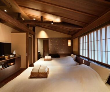 Two futon beds on tatami floor with shoji screens and wooden beams in Muromachi Yutone Kyokoyado Kyoto