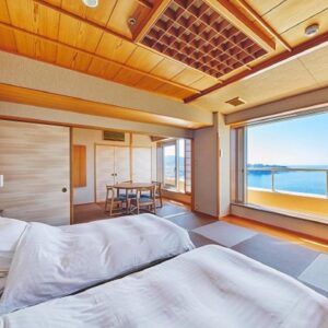 Tatami room with twin beds, shoji screens and sea view at Musashi in Wakayama