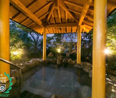Covered outdoor onsen bath under wooden gazebo with lantern-lit garden at Mutsumikan in Gifu