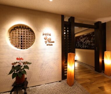 Entrance corridor with round lattice window, potted plant and wooden lanterns at Mutsumikan, Gifu, Chūbu