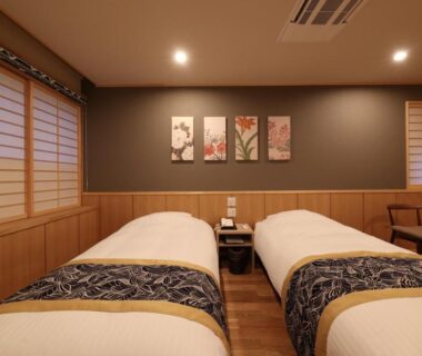 Twin beds with shoji screens and warm wooden interior at Mutsumikan in Chūbu, Gifu