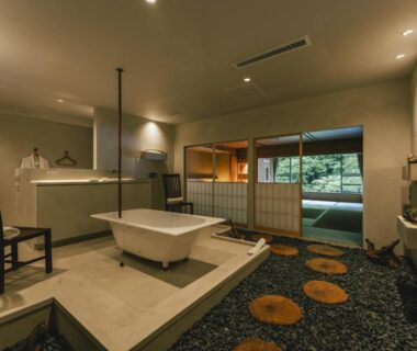 Interior room with freestanding bathtub, shoji screens, and garden outlook at Myojinkan in Nagano