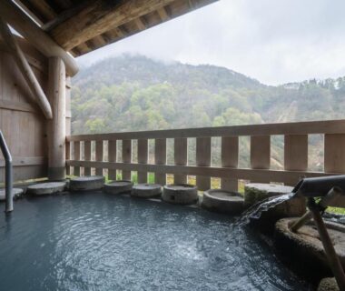 Wooden onsen bath on balcony with mountain view at Myoko Tsubame in Niigata
