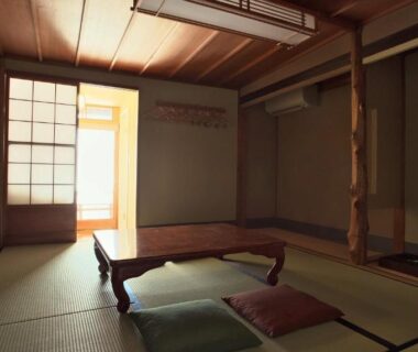 Traditional tatami room with low table, zabuton cushions, shoji screens and warm natural light at NAGOMI Kyoto Okazaki