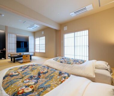 Futon bedding on tatami with shoji screens, low table and TV at NISHIYAMA RYOKAN Kyoto