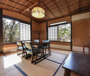 Tatami room with dining table, shoji screens and garden view at Nagataki in Gifu